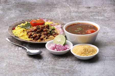 Aloo/Kanda Poha or Tarri Pohe with spicy chana masala/curry. Served in ceramic plate.の写真素材