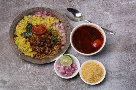 Aloo/Kanda Poha or Tarri Pohe with spicy chana masala/curry. Served in ceramic plate.の写真素材