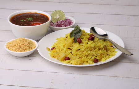 Aloo/Kanda Poha or Tarri Pohe with spicy chana masala/curry. Served in ceramic plate.の写真素材