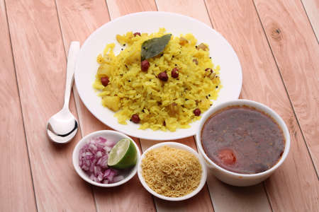 Aloo/Kanda Poha or Tarri Pohe with spicy chana masala/curry. Served in ceramic plate.の写真素材