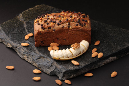 Homemade banana bread with walnut, almonds on a stone background.の写真素材
