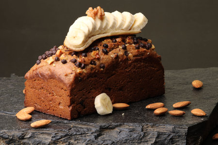 Homemade banana bread with walnut, almonds on a stone background.の写真素材