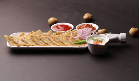 Traditional Indian food Aloo paratha or potato stuffed flat bread. served with pickle tomato ketchup and curd, butter, onion chili.の写真素材