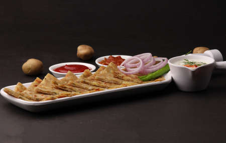 Traditional Indian food Aloo paratha or potato stuffed flat bread. served with pickle tomato ketchup and curd, butter, onion chili.の写真素材