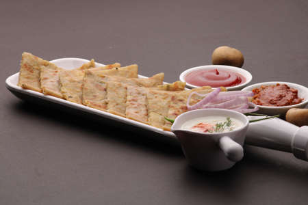 Traditional Indian food Aloo paratha or potato stuffed flat bread. served with pickle tomato ketchup and curd, butter, onion chili.の写真素材