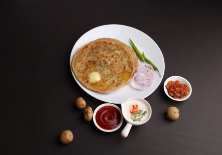 Traditional Indian food Aloo paratha or potato stuffed flat bread. served with pickle tomato ketchup and curd,の写真素材
