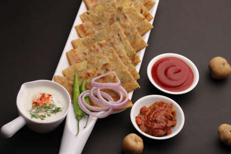 Traditional Indian food Aloo paratha or potato stuffed flat bread. served with pickle tomato ketchup and curd, butter, onion chili.の写真素材