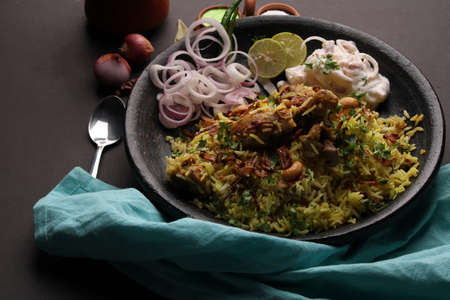 chicken dum biriyani served in earthen  plate with onion raita.の写真素材
