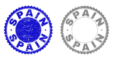 Grunge SPAIN stamp seals isolated on a white background. Rosette seals with grunge texture in blue and grey colors. Vector rubber stamp imprint of SPAIN label inside round rosette.のイラスト素材