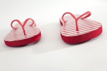 Red with white stripes flip-flops on a white background の写真素材