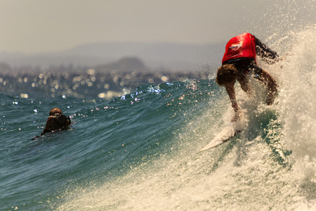 SNAPPER ROCKS, GOLD COAST, AUSTRALIA - 5 MARCH  Unidentified Surfer races the Quiksilver   Roxy Pro World Title Event  5 March 2014, Snapper Rocks, Gold Coast, Australia のeditorial素材