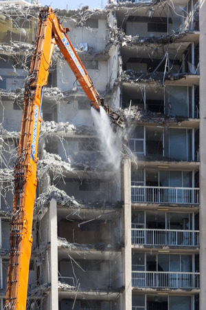 GOLD COAST, AUSTRALIA-OCTOBER 15  Special demolition machine with water jet brakes older building down in a heavily populated sea shore area without much airpolution  Oct 15 2013 Gold Coast Australia  のeditorial素材