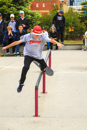 CALGARY, CANADA - JUN 21, 2015: Athletes have a friendly skateboard Show Off in Calgary. California law requires anyone under the age of 18 to wear a helmet while riding a skateboard. CALGARY, CANADA - JUN 21, 2015: Athletes have a friendly skateboard Show Off in Calgary. California law requires anyone under the age of 18 to wear a helmet while riding a skateboard.