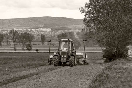 Hungary (Somewhere in the countryside) May 02, 2020:  Farmer with a tractor plant seeds in the soil at springtime.のeditorial素材