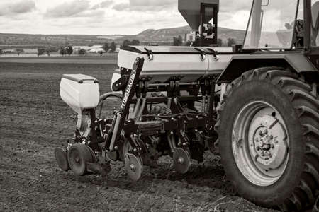 Debrecen Hungary - May 2020: Modern tractor towing a seed planting machine on a ploughed field in a rural area in Hungary in Springtime.のeditorial素材