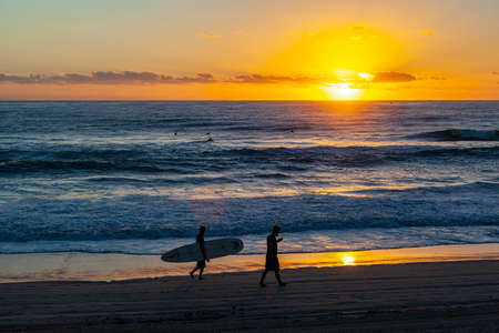 Surfers Paradise Nov11, 2019: Two unidentified men walking on the sandy beach while  looking for good surf.のeditorial素材
