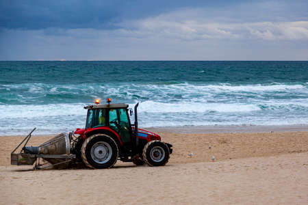 Surfers Paradise Australia Feb 11,2019: Tractor cleaning the beach at sunrise every morning for the...