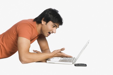 Man working on a laptop and surprisedの写真素材