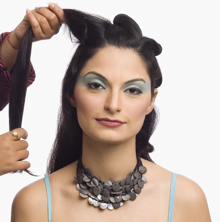 Person's hands styling a young woman's hairの写真素材