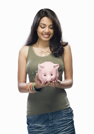 Young woman holding a piggy bankの写真素材