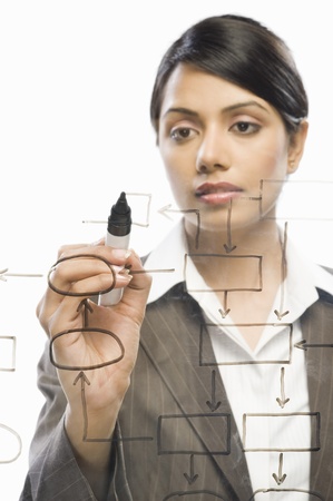 Businesswoman making flow chart on a glass against a white backgroundの写真素材