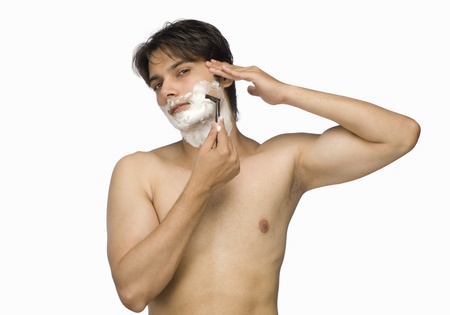 Young man shaving his faceの写真素材