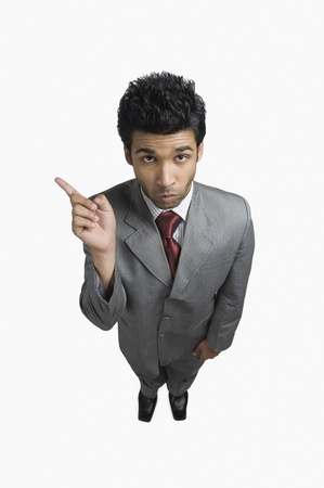 Businessman making a face and pointingの写真素材
