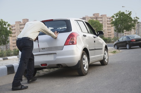 Businessman pushing his carの写真素材