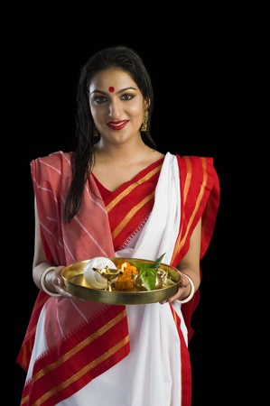 Beautiful woman in a Bengali sari holding pooja thali