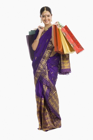 Beautiful Assamese woman holding shopping bags and smilingの写真素材
