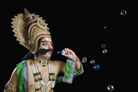 Man dressed-up as Ravana and blowing bubblesの写真素材