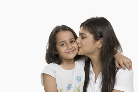 Close-up of a woman kissing her daughter