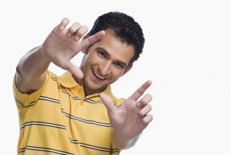 Portrait of a man making a finger frame and smilingの写真素材