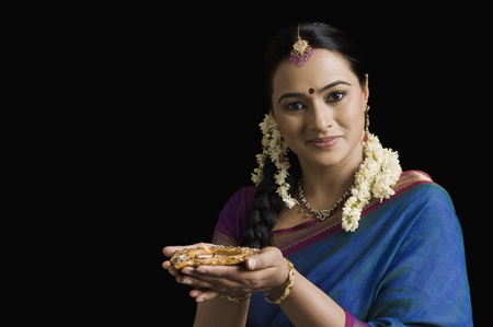 Woman praying with an oil lampの写真素材