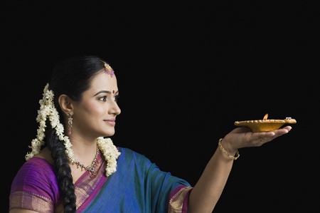 Woman praying with an oil lampの写真素材