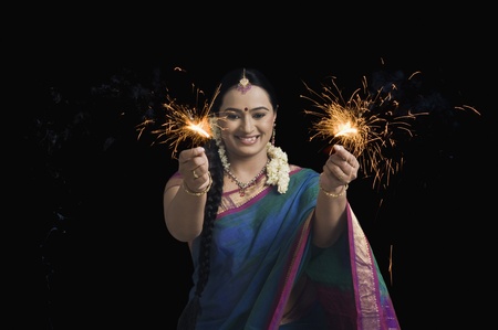Woman celebrating Diwali festival with sparklersの写真素材