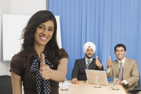 Business executives showing thumbs up and smilingの写真素材
