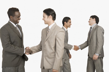 Four businessmen shaking handsの写真素材