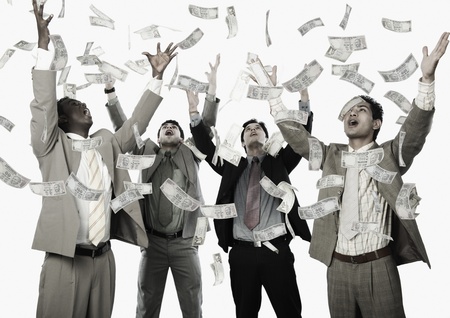 Banknotes falling over four businessmenの写真素材