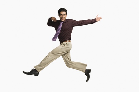 Portrait of a businessman leaping against a white backgroundの写真素材