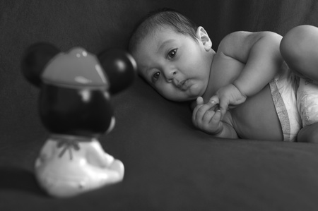 Baby boy looking at a toyの写真素材