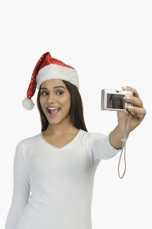 Woman taking a picture of herself with a digital cameraの写真素材