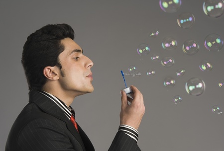 Businessman blowing bubblesの写真素材