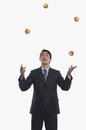 Businessman juggling with applesの写真素材