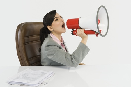 Businesswoman shouting into a megaphoneの写真素材