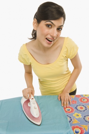 Woman ironing clothes at homeの写真素材