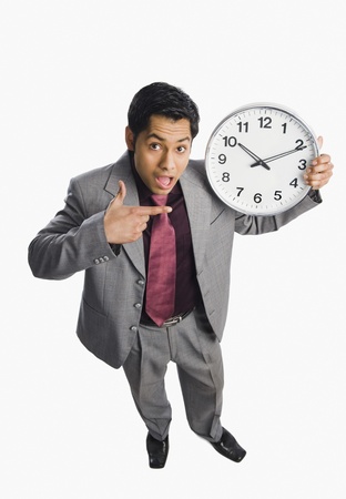 Businessman showing a clockの写真素材