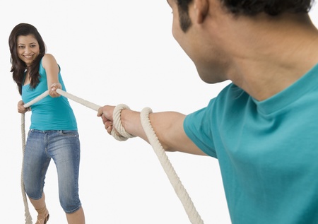 Young couple playing tug of war