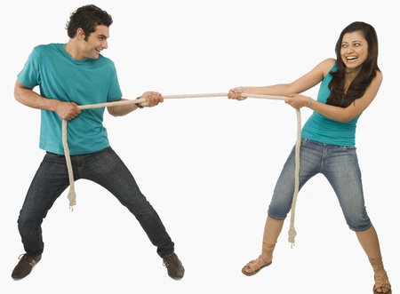 Young couple playing tug of warの写真素材