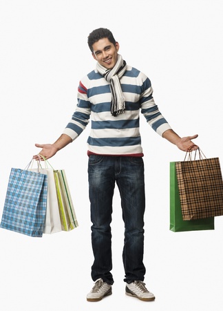 Portrait of a man carrying shopping bagsの写真素材